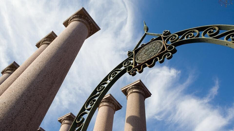 Skyward image or of campus columns and gate near Memorial Stadium.